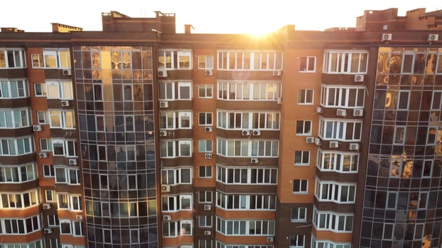 The sunlight is pouring through the windows of a towering building, illuminating the facade of the urban design structure in the city sky