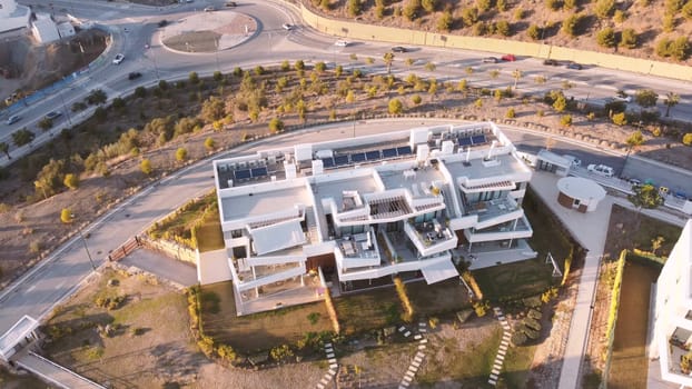 The building has a glass facade and is surrounded by trees