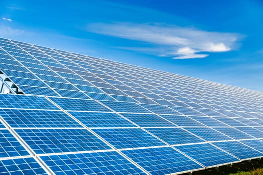 Photovoltaic modules of huge solar panels with blue sky on background. concept of sustainable resources.