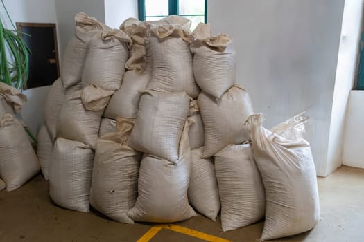 A pile of white sacks stacked on top of each other. The sacks are filled with something, but it is not clear what it is. The scene has a sense of mystery and curiosity