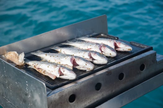 BBQ grilled sea fish fried on a boat while sailing, wonderful summer holiday in Turkey, tourist high service