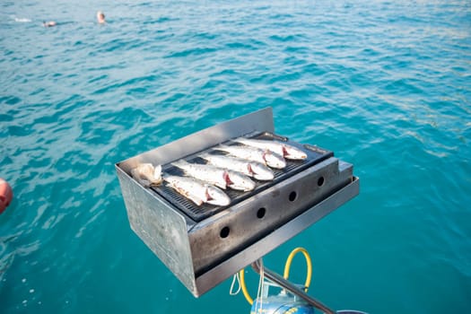 BBQ grilled sea fish fried on a boat while sailing, wonderful summer holiday in Turkey, tourist high service