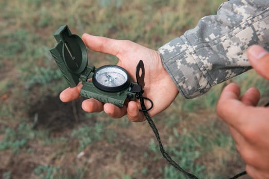 Man with compass in hand outdoor. Travel concept.