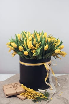 Bright spring bouquet of tulips and mimosa flowers. Mother's Day or Easter theme.