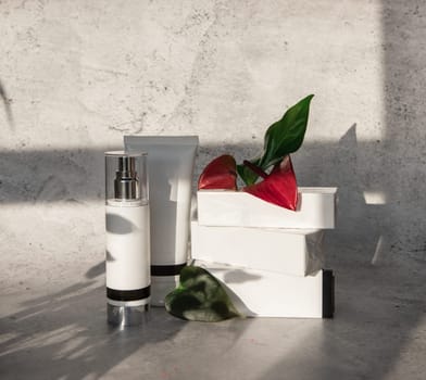 Cosmetic bootles with flowers o n gray background