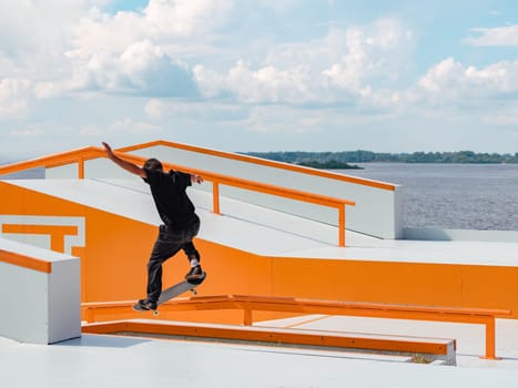 Latino Boy doing skateboard trick on rail in skatepark. Professional skater sportsman grinding on skateboard in outdoor park. Faceless unrecognizable Latin skater doing Grind trick. Skate background