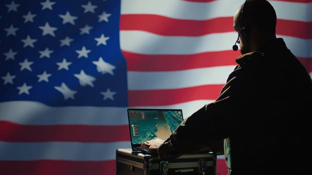 US Air Force agent using radar system on laptop to detect incoming ballistic missiles. American NATO army soldier scanning rockets approaching borders, deploying shields, United States flag, camera B