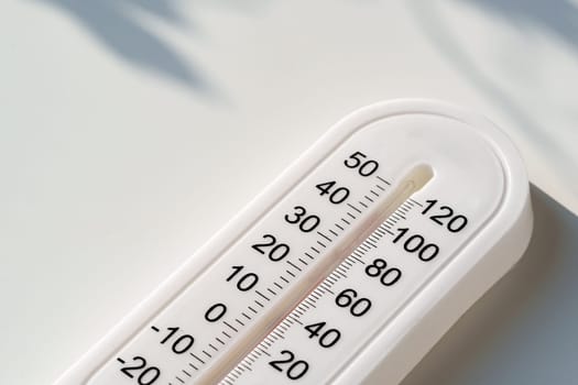 This image shows a white plastic thermometer lying flat on a white surface.