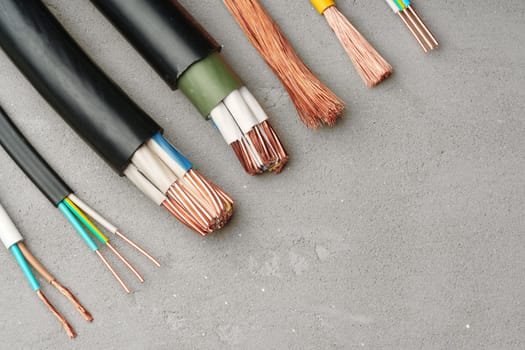 This image shows a variety of electrical tools and wires laid out on a gray surface.