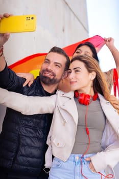 Happy multiethnic group of young gay friends take a selfie together on campus. Multiracial students meeting in the city, concepts of youth, people's lifestyle, diversity and pride.