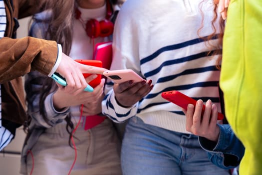 Group of friends using looking at their smartphones Multiracial teenagers browsing the internet with mobile phone on campus