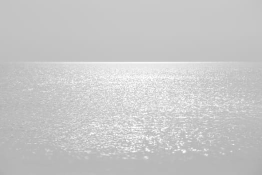Sun glare on the sea surface in calm, breezy weather. Natural background and texture.