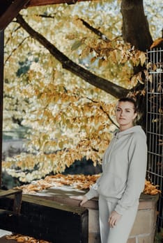 Beautiful elegant woman standing in a park in autumn. autumn yellow leaves. Portrait of joyful woman in park during fall. Happy girl with yellow leaves outdoor. Beauty Romantic Girl Outdoors enjoying nature. Beautiful autumn model with waving glow hair.Sun light on sunset.Warm toned art work. Portrait of romantic female