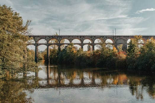 Railway Bridge with river in Bietigheim-Bissingen, Germany. Autumn. Railway viaduct over the Enz River, built in 1853 by Karl von Etzel on a sunny summer day. Bietigheim-Bissingen, Germany. Old viaduct in Bietigheim reflected in the river. Baden-Wurttemberg, Germany. Train passing a train bridge on a cloudy day in Germany