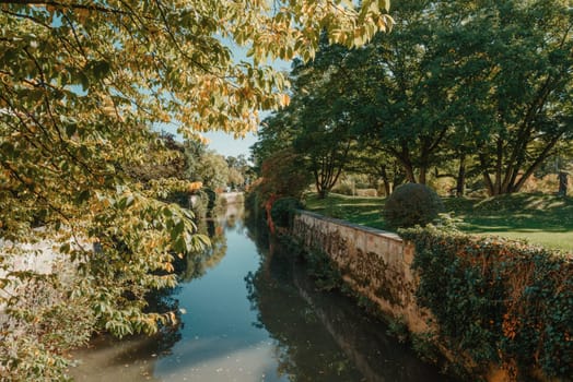 A wooden bridge in the park with and autumn colors of Bietigheim-Bissingen, Germany. Europe. Autumn landscape in nature. Autumn colors in the forest. autumn view with wooden bridge over stream in the park in autumn season