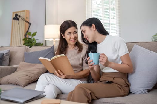 An elderly mother and her daughter spend quality time together at home, sharing a moment of relaxation and bonding on the couch.