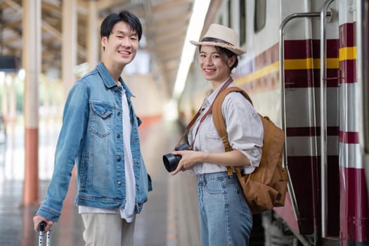 A cheerful couple traveling by train, equipped with a camera and luggage, ready for an exciting journey. Perfect for travel, adventure, and lifestyle themes.