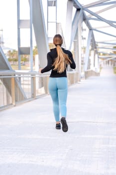 Fitness girl is running outdoors. Concept of workouts and healthy lifestyle.