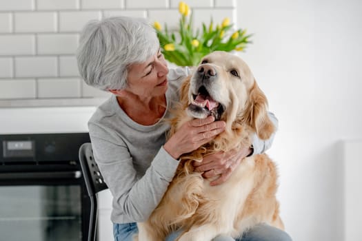 Woman With Grey Hair Enjoys Time At Home With Golden Retriever