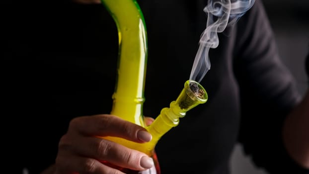 Woman Smokes Cannabis With Bong In Close-Up View