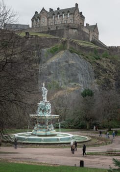 Edinburgh, Scotland - Jan 16, 2024 - Scenic view of Ross Fountain with Edinburgh Castle at the top of the hill at West Princes Street Garden in the centre of Edinburgh. is one of the most popular tourist attractions in Edinburgh, Space for text, Selective focus.