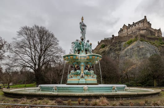 Edinburgh, Scotland - Jan 16, 2024 - Scenic view of Ross Fountain with Edinburgh Castle at the top of the hill at West Princes Street Garden in the centre of Edinburgh. is one of the most popular tourist attractions in Edinburgh, Space for text, Selective focus.