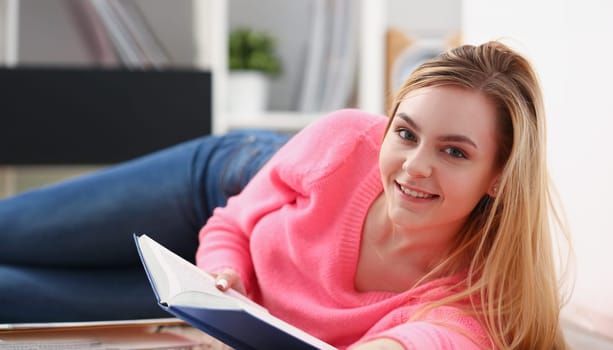 young beautiful blond woman lie on the floor read book enjoy study concept
