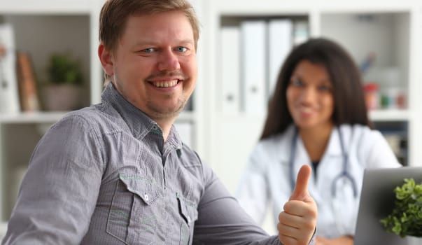 Man showing ok sign with thumb up at physician office portrait. High level work confident satisfied male do like visit to clinic best occupation emergency help teamwork concept