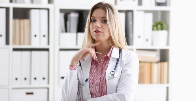 Beautiful smiling female doctor sit at workplace. Physical and disease prevention, patient aid, exam visit, 911, ward round, prescribe remedy, healthy lifestyle, consultant profession concept
