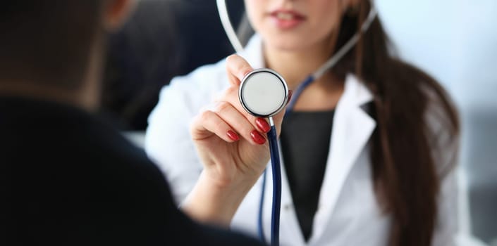 Beautiful smiling female doctor hold in arm stethoscope head going to listen patient. Tool shop or store physical disease prevention er consultant 911 pulse measure healthy lifestyle concept