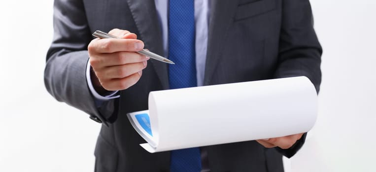Male arm in suit and tie fill form clipped to pad with silver pen closeup. Sign gesture read pact sale agent bank job make note loan credit mortgage investment finance chief legal law concept