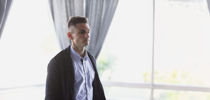 Portrait of a young attractive handsome businessman in a cafe expects business partners for a seminar
