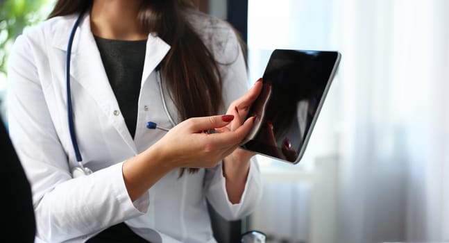 Beautiful female medicine doctor explain diagnosis to patient holding and showing digital tablet pc. Physical disease prevention 911 prescribe remedy healthy lifestyle modern technology concept