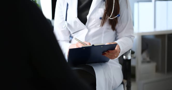 Female doctor hand hold silver pen filling patient history list at clipboard pad. Physical exam er disease prevention ward round visit check 911 prescribe remedy healthy lifestyle concept