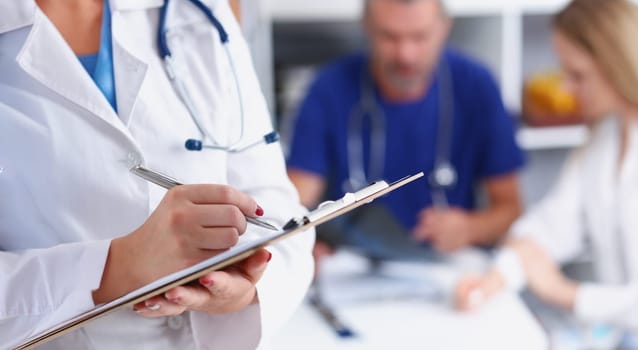 Female doctor hold clipboard pad and fill medical history list with silver pen. Physical illness prevention 911 prescribe remedy ward round therapeutist assistance healthy lifestyle concept