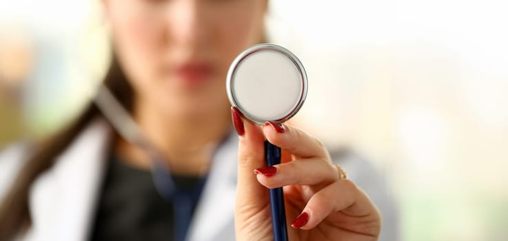 Beautiful smiling female doctor hold in arm stethoscope head going to listen patient. Tool shop or store physical disease prevention er consultant 911 pulse measure healthy lifestyle concept