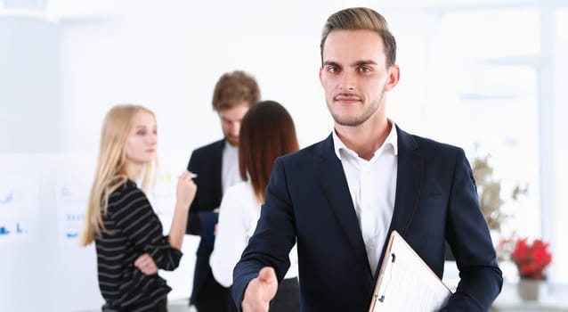 Smiling handsome cheerful man offer hand as hello in office portrait. Serious excellent prospect, friendly support service introduction or thanks gesture gratitude invite to participate concept