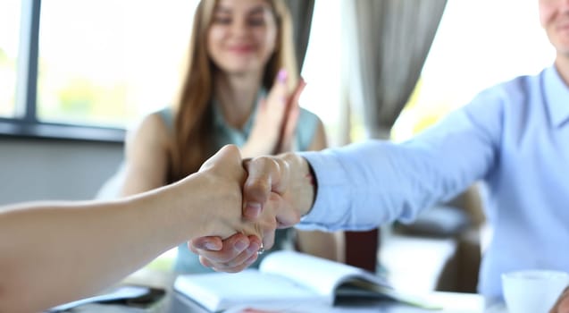 Smiling man and woman shake hands as hello in cafe portrait. Friend welcome mediation offer positive introduction greet or thanks gesture summit participate approval strike arm bargain concept