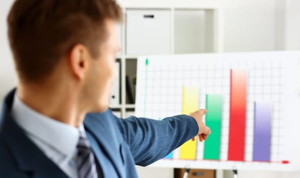 Man in suit point with arm in stats graph in office closeup. Stock exchange market advisor sale examination industry profit research occupation account career present ambition negotiation study trade