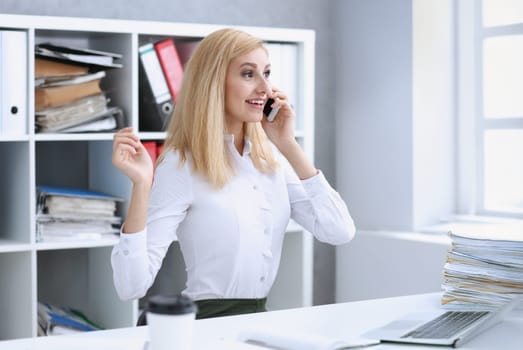 Beautiful blonde smiling businesswoman talk cellphone in office portrait. Stay in touch best cellular price A woman is informed that she won a prize in the lottery by phone