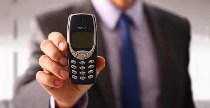 Illustrative Editorial Image. Minsk, Belarus, December 1, 2024 Businessman holding vintage phone nokia 3310 in hand