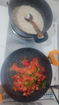 food in a frying pan and in a saucepan on the stove, cooking, vegetables and porridge. High quality photo