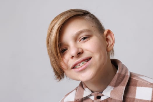 close-up portrait of a teenager with braces, the boy is happy with braces. beautiful teeth concept