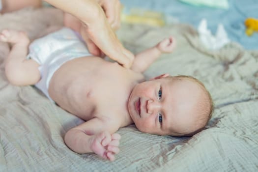 The newborn's skin is peeling. Mom uses skin products and massages to care for and soothe the baby's delicate skin, ensuring comfort and promoting healthy skin.