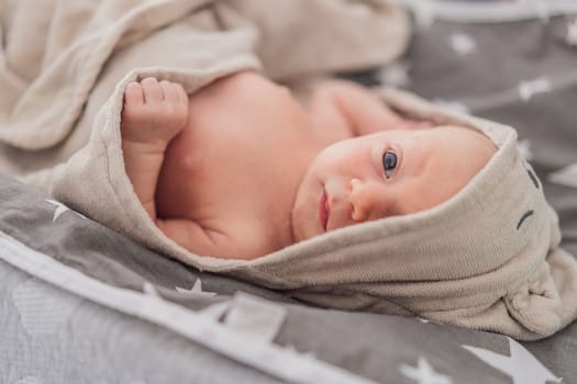 Baby after shower wrapped in a towel. This adorable moment captures the freshness and comfort of a clean baby, highlighting the tender care and love in the daily routine.