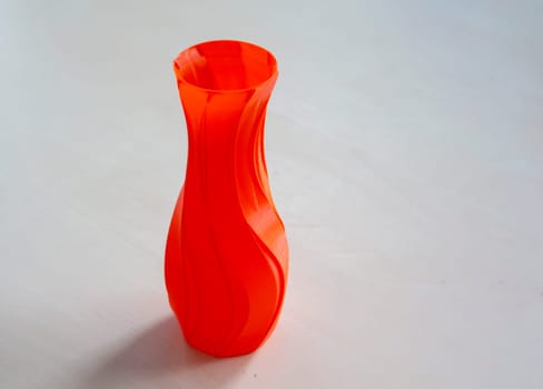 Object in the form of a vase of red color printed on a 3D printer. Three-dimensional model printed on a 3D printer from molten plastic of red color. Concept 3D Printing. FDM 3D Printing technology