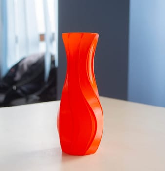 Object in the form of a vase of red color printed on a 3D printer. Three-dimensional model printed on a 3D printer from molten plastic of red color. Concept 3D Printing. FDM 3D Printing technology