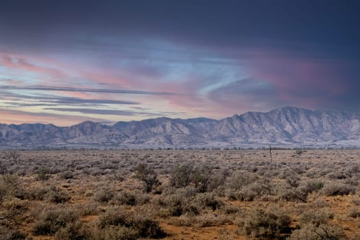 Dawn over Wilpena Pound in Ikara Flinders Ranges, vibrant sky, rugged mountains.