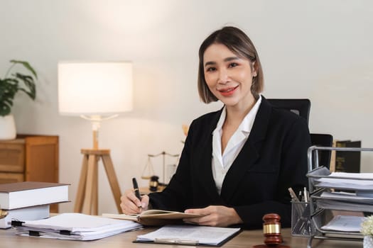 A professional female lawyer examines contract documents related to a lawsuit in a modern office environment.