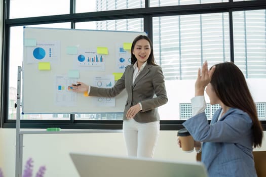 A young accountant in a modern office presents financial graphs and data analysis to a colleague, showcasing business growth and performance.